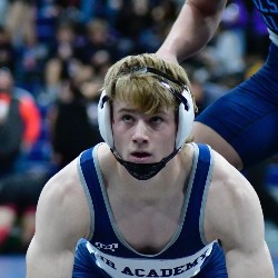 An AAHS wrestler looks up at a referee during a competition.